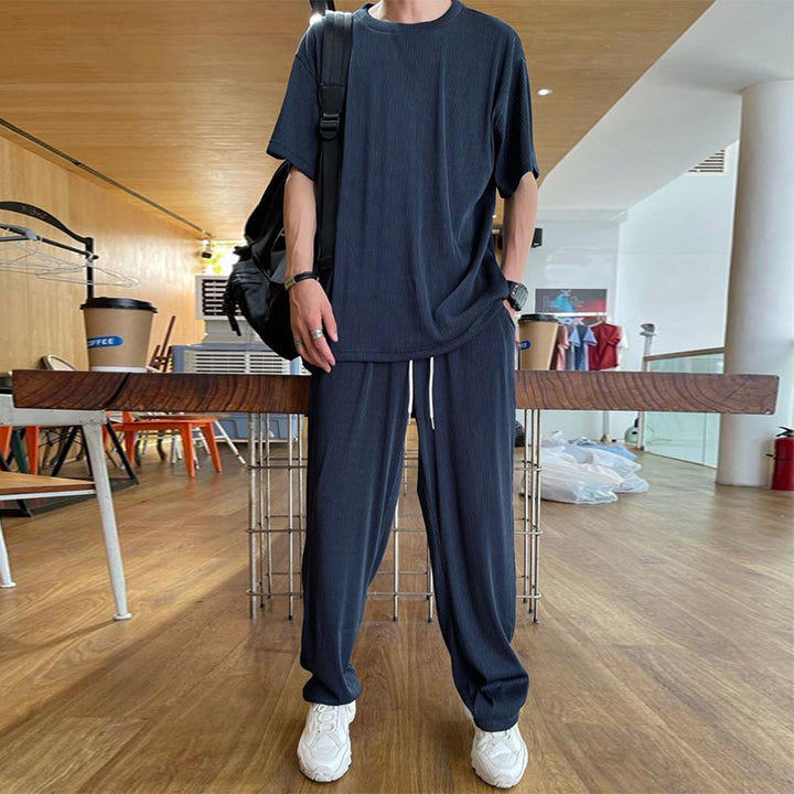 "Herrbyxset av is-silke, rund hals, vita elastiska byxor, praktiska fickor, avslappnad passform, stilren design"