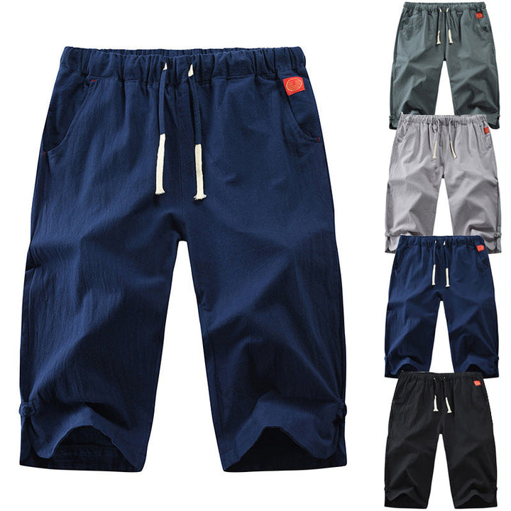 "Herrshorts i beige bomull-linne, dragsko och tre fickor, framifrån i soligt väder"