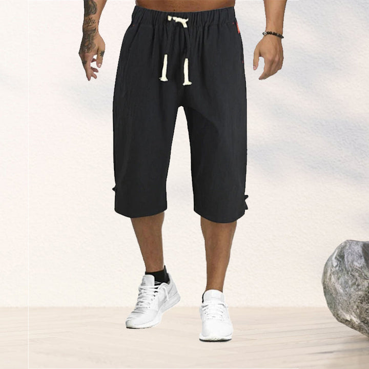 "Herrshorts i beige bomull-linne, dragsko och tre fickor, framifrån i soligt väder"