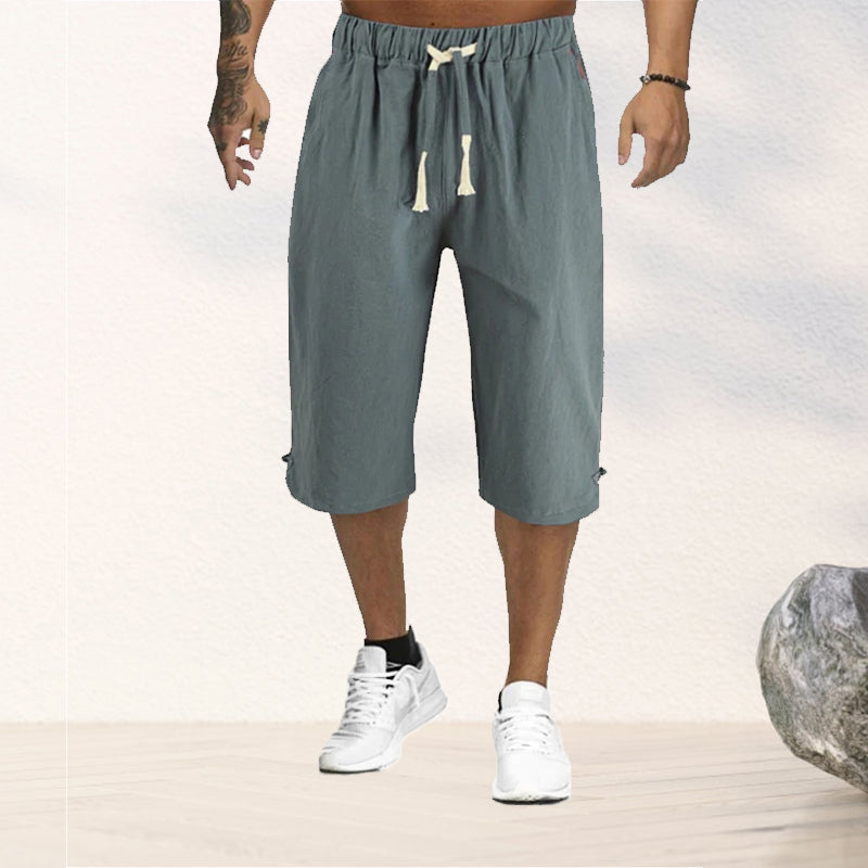 "Herrshorts i beige bomull-linne, dragsko och tre fickor, framifrån i soligt väder"