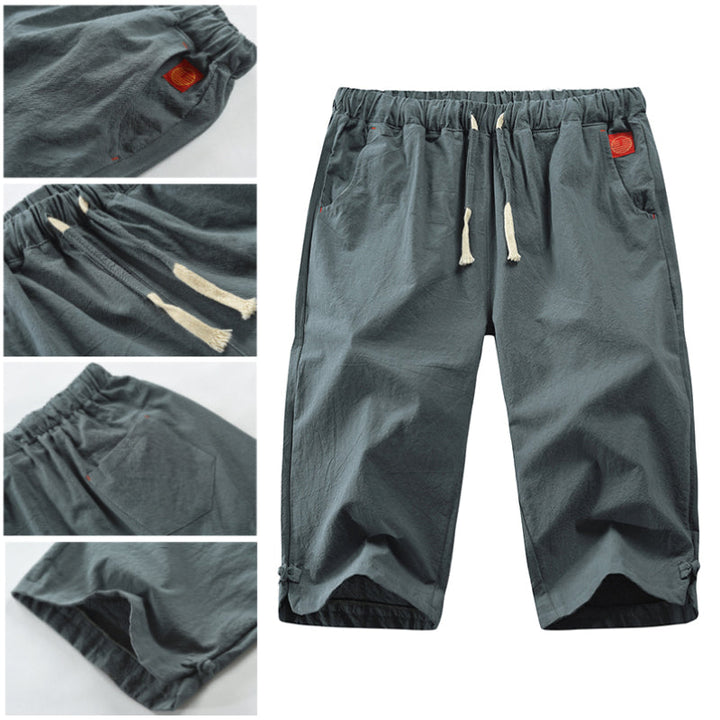 "Herrshorts i beige bomull-linne, dragsko och tre fickor, framifrån i soligt väder"