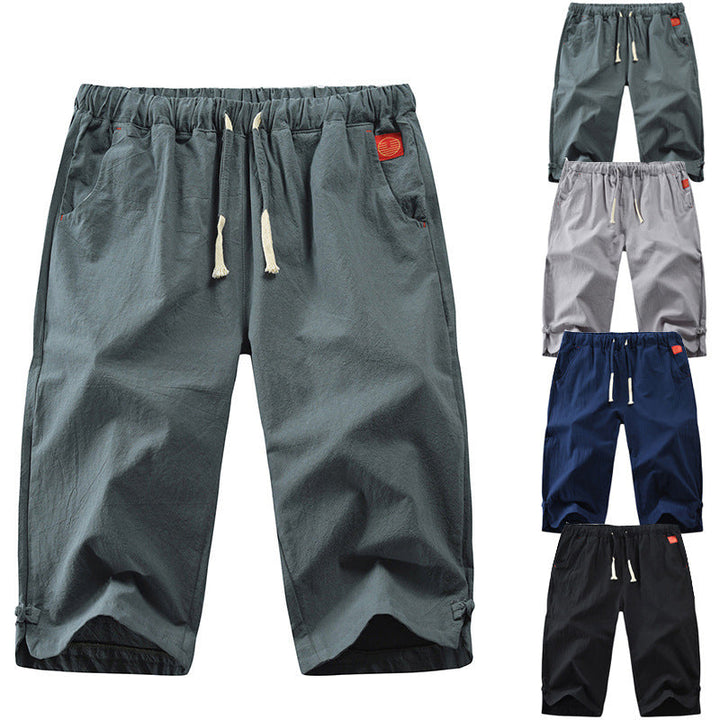 "Herrshorts i beige bomull-linne, dragsko och tre fickor, framifrån i soligt väder"