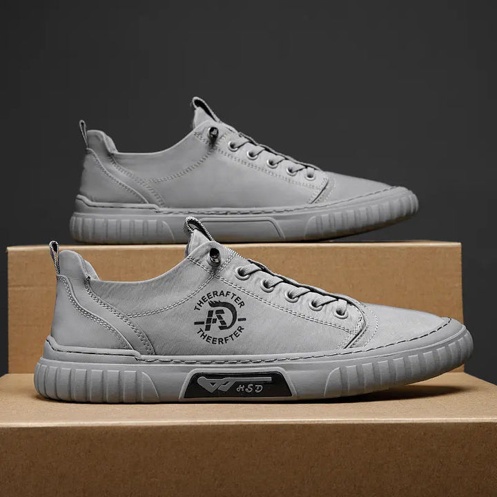 "Högklassiga herrsneakers i grått med elastiska snören och antihalksula, perfekt för stil och komfort."