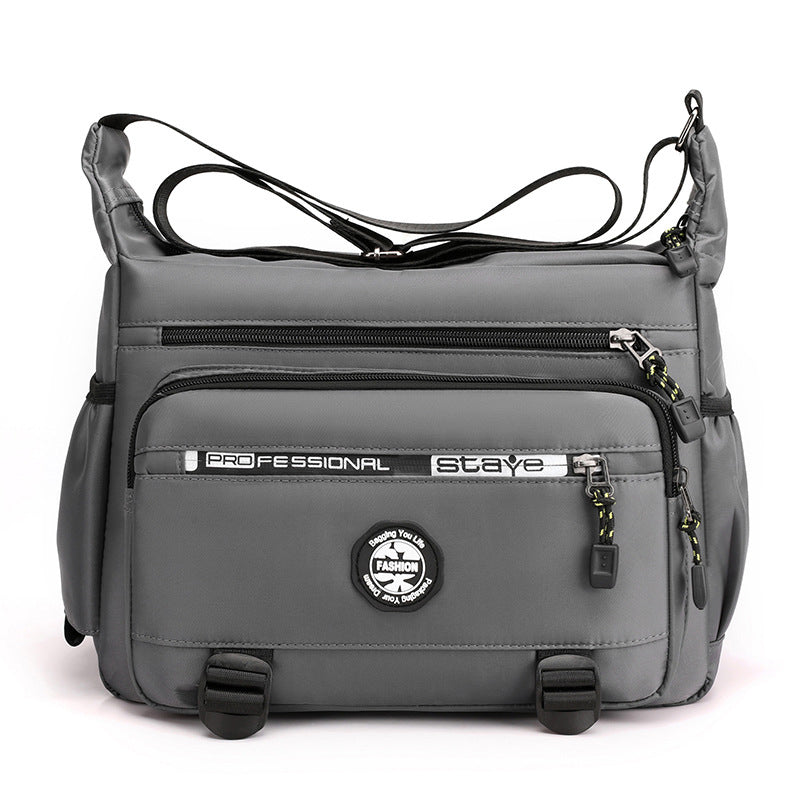 "Högkvalitativ svart axelväska för män med flera fickor, justerbara remmar och vattentät yta, sedd bakifrån."