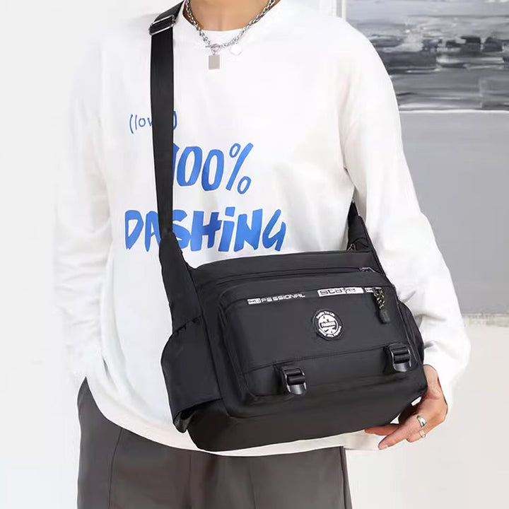 "Högkvalitativ svart axelväska för män med flera fickor, justerbara remmar och vattentät yta, sedd bakifrån."