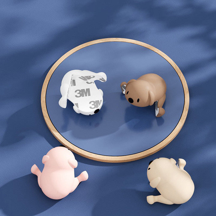 "Hörnskydd i silikon, tecknad design, rosa ton, skyddar barn från skarpa hörn, perfekt för soffbord och stolar."