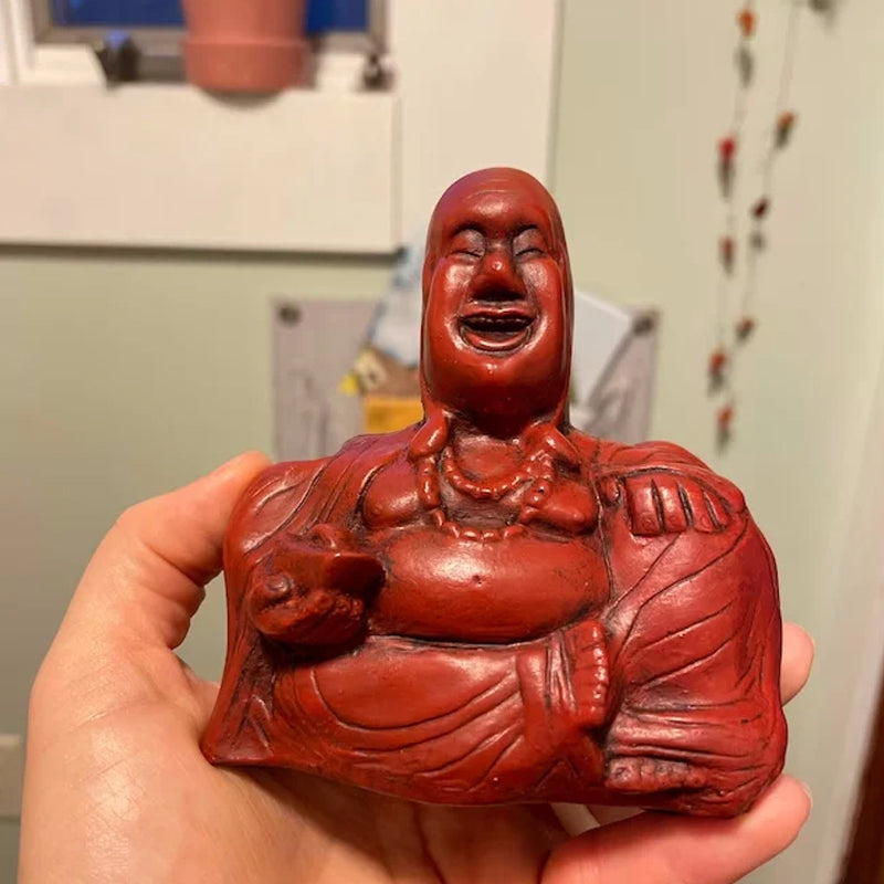 Humoristisk Buddha figur med utsträckt långfinger, gjord av harts, perfekt för skrivbord eller hylla, väcker skratt.