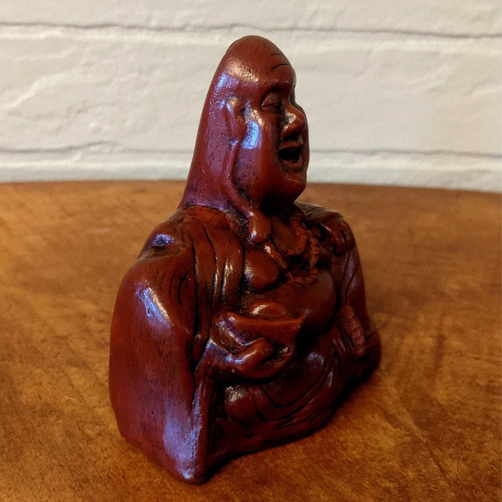 Humoristisk Buddha figur med utsträckt långfinger, gjord av harts, perfekt för skrivbord eller hylla, väcker skratt.