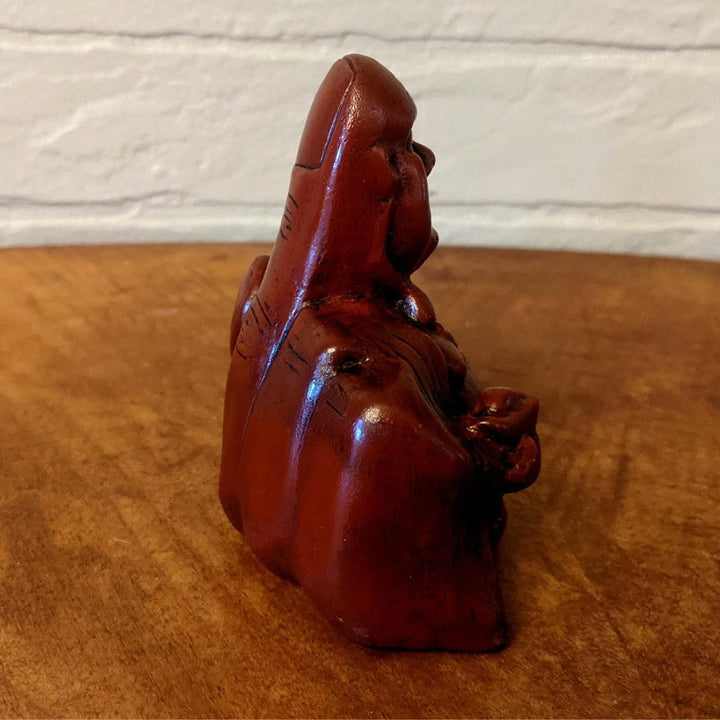 Humoristisk Buddha figur med utsträckt långfinger, gjord av harts, perfekt för skrivbord eller hylla, väcker skratt.