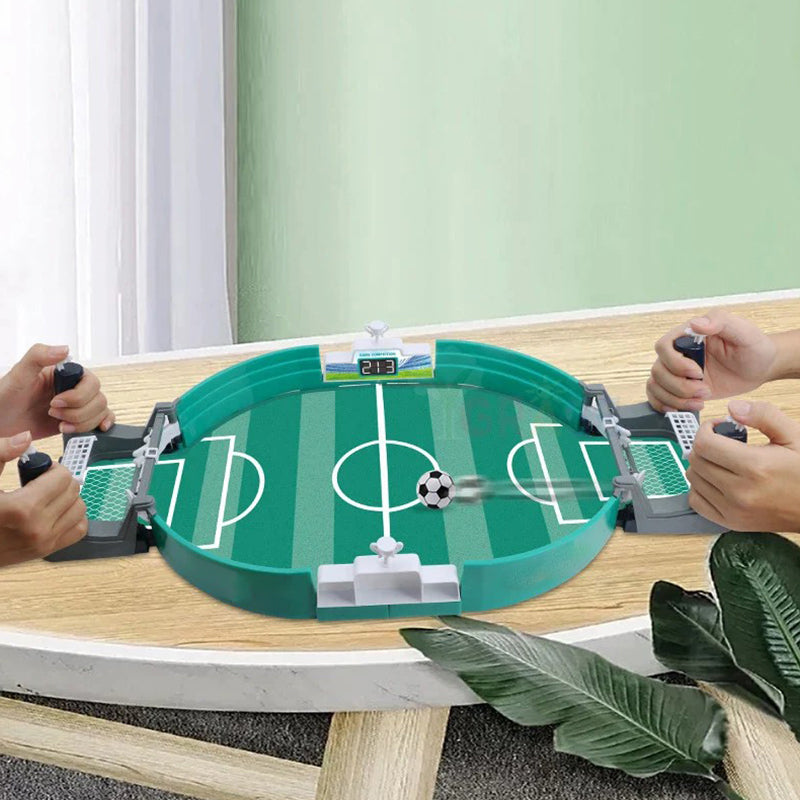 Interaktivt bordfotbollsspel för familjen, grön plast, närbild av planen och spelare, främjar motorik och samspel.