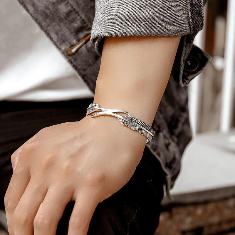 "Justerbart silverfjäderarmband för kvinnor, nickelfritt och elegant design med symboliskt fjädermotiv."
