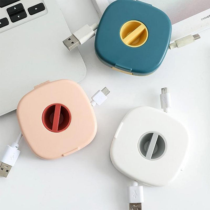 "Kabelupprullare och telefonstativ i hållbart ABS-material, finns i blå, vit och rosa, perfekt för kabelorganisation."