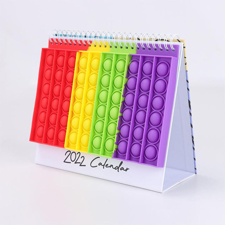 "Kalender med färgglada silikonbubblor för stresslindring och planering, perfekt för hem och kontor, i hållbart material."