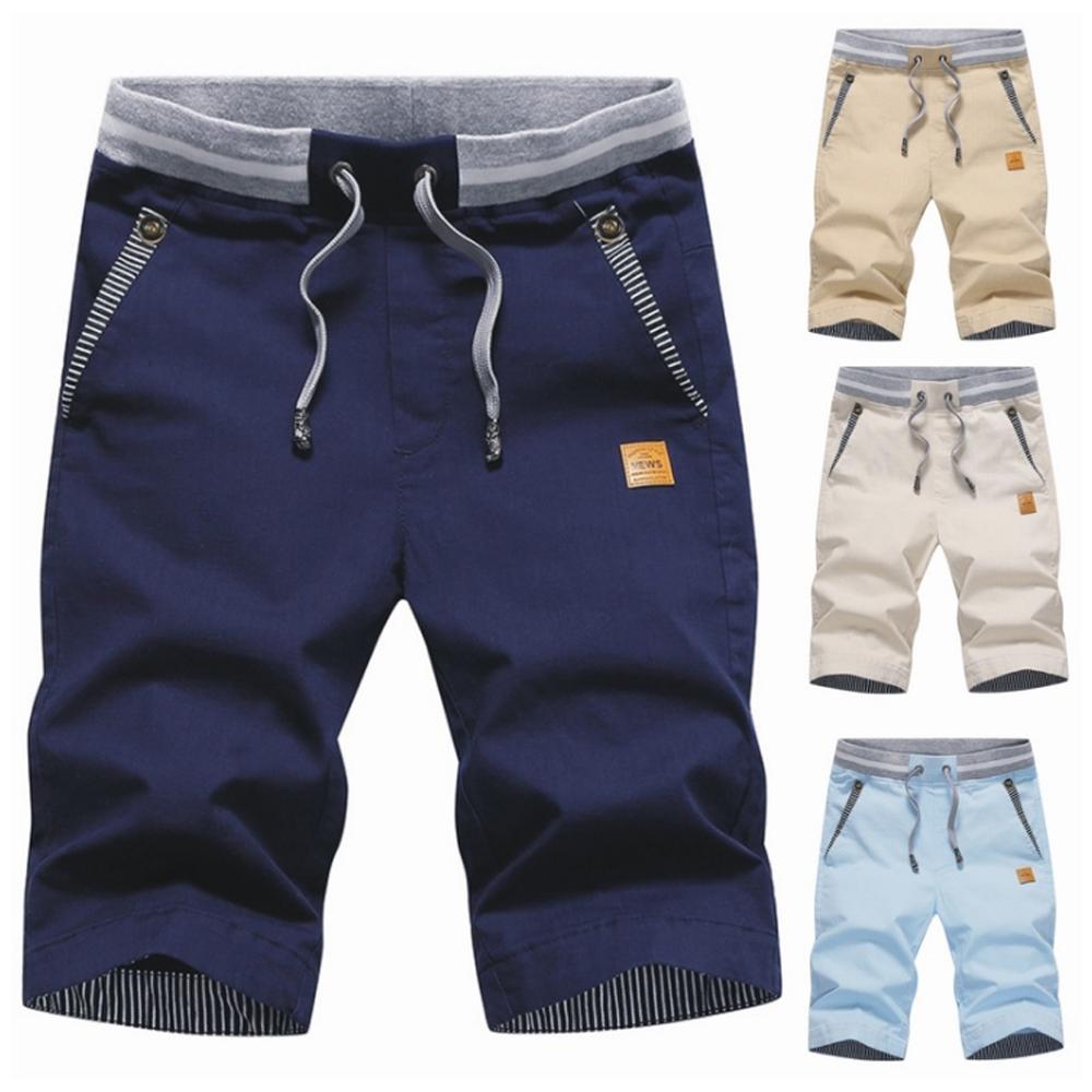 "Mäns casual shorts med elastisk midja i bomull, randig fickdetalj och bakfickor, visad framifrån i ljusgrå nyans."