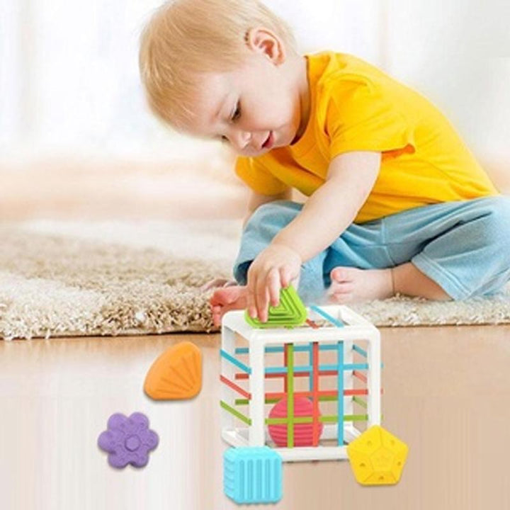 Multifärgad pedagogisk barnleksak med sensoriska funktioner, runda hörn och elastiska rep för småbarns utveckling.