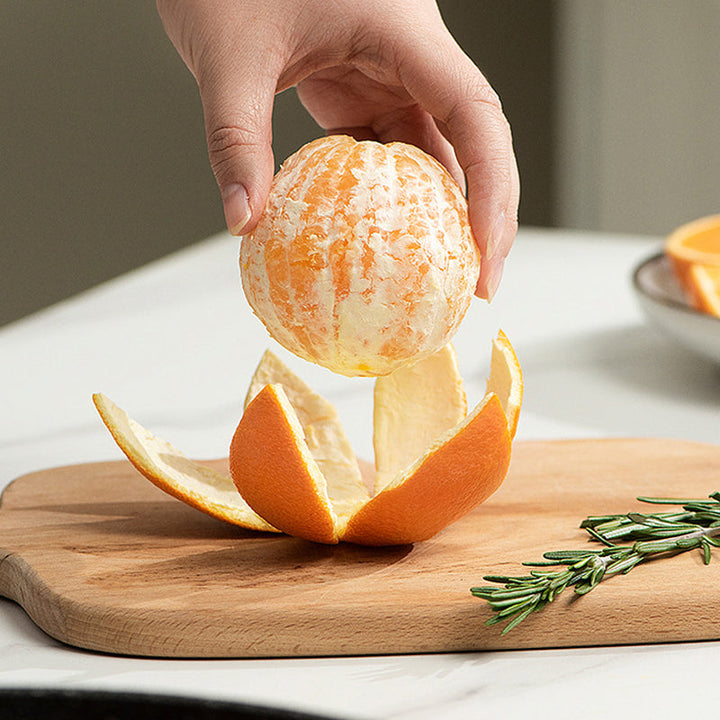 "Multifunktionellt fruktskalningsverktyg i grönt, hållbart material, perfekt för att enkelt skala frukt i köket."