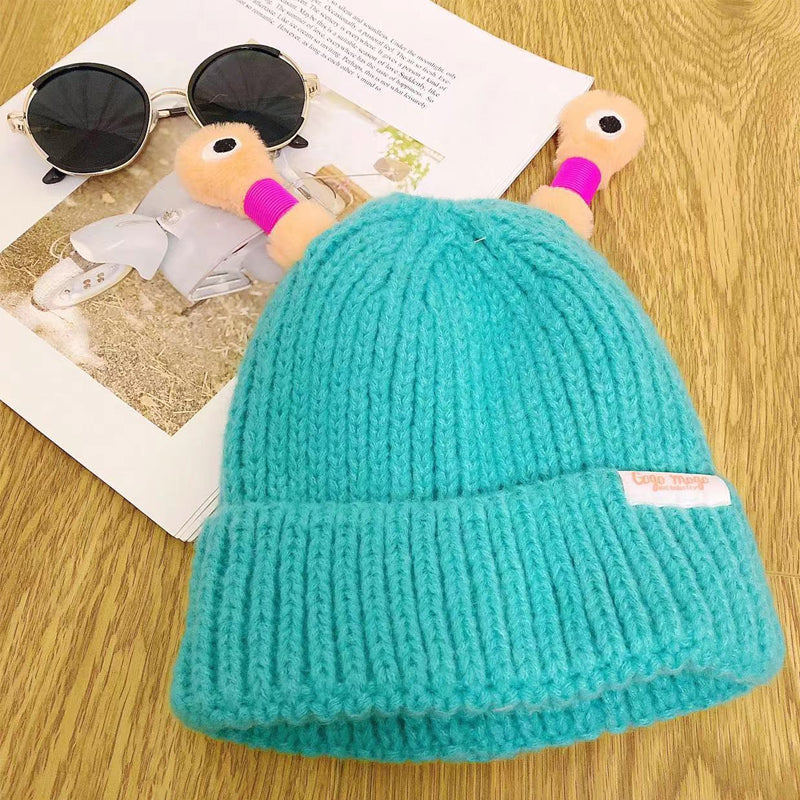 "Mysig vinterstickad mössa för barn och vuxna med monsterdesign och stora ögon i olika färger."
