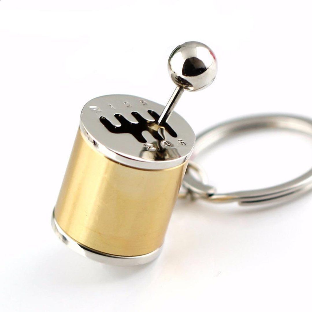 "Nyckelring med manuell växelspak i metall, realistisk design med sex växlar, perfekt för bilentusiaster."