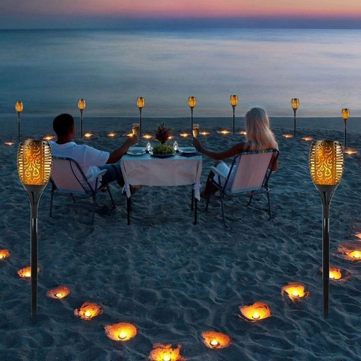 Solcellsdriven LED-bordslampa med flammande ljus, skimrar som naturliga eldflammor; perfekt för atmosfärisk utomhusbelysning.