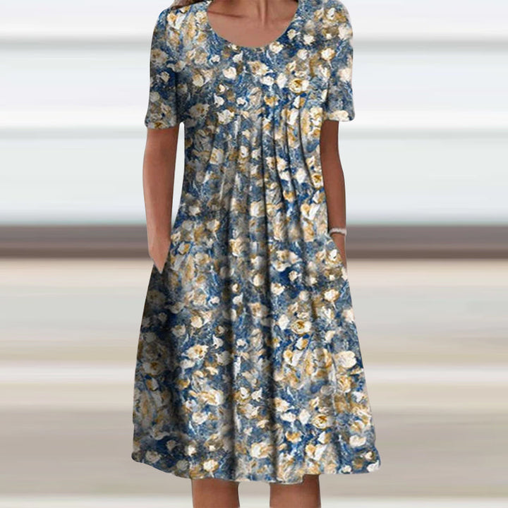 "Somrig blommig damklänning med korta ärmar, rund hals och feminin look, perfekt för avslappnade sommaräventyr."