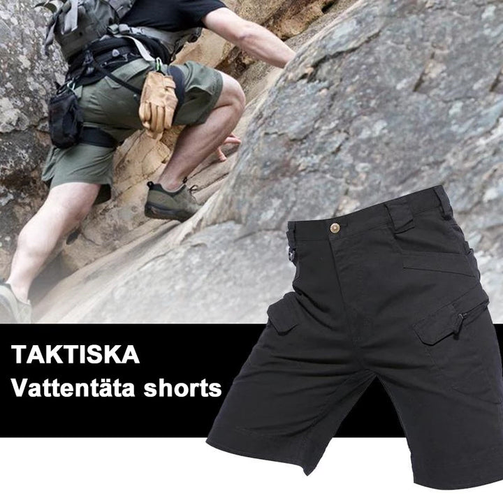 "Vattentåliga herrvandrarshorts med flera fickor, elastiskt midjeband och förstärkt tyg i grön färg, främre vy."
